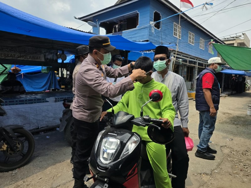 Kapolsek Pelangiran Bersama Personel Bagikan Masker kepada Warga Hadapi Kabut Asap Karhutla